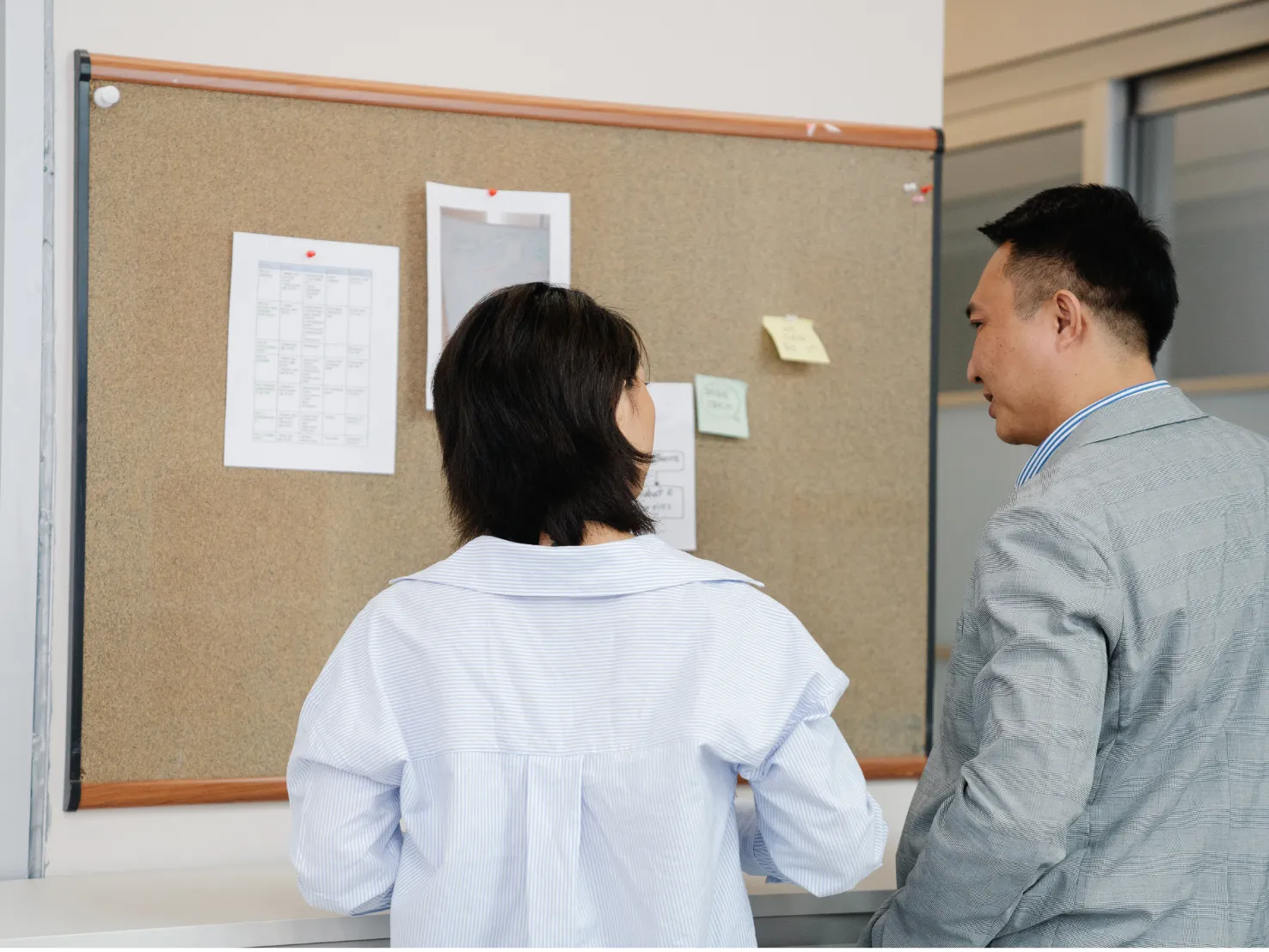 住戶查看公寓大樓公告欄上的社區通知